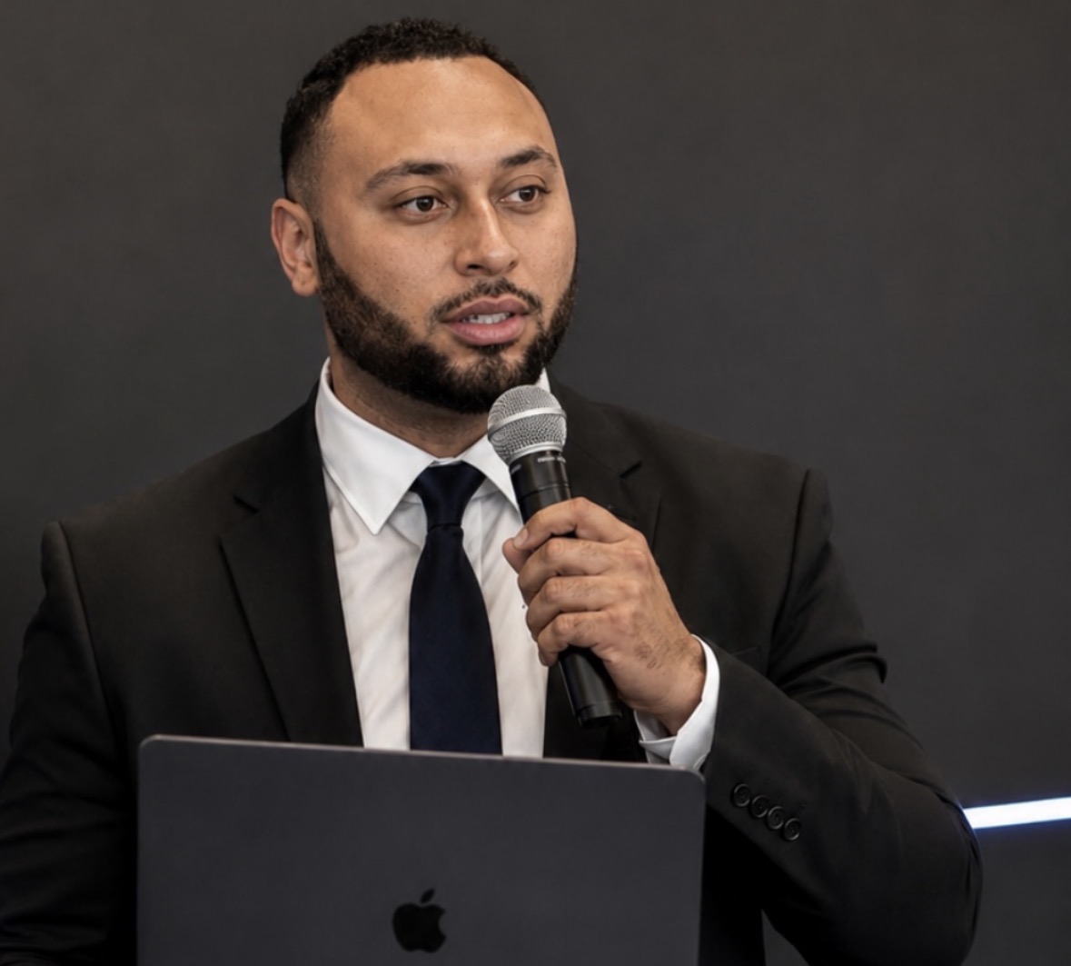 Avery Stilley speaking into a microphone at a professional event
